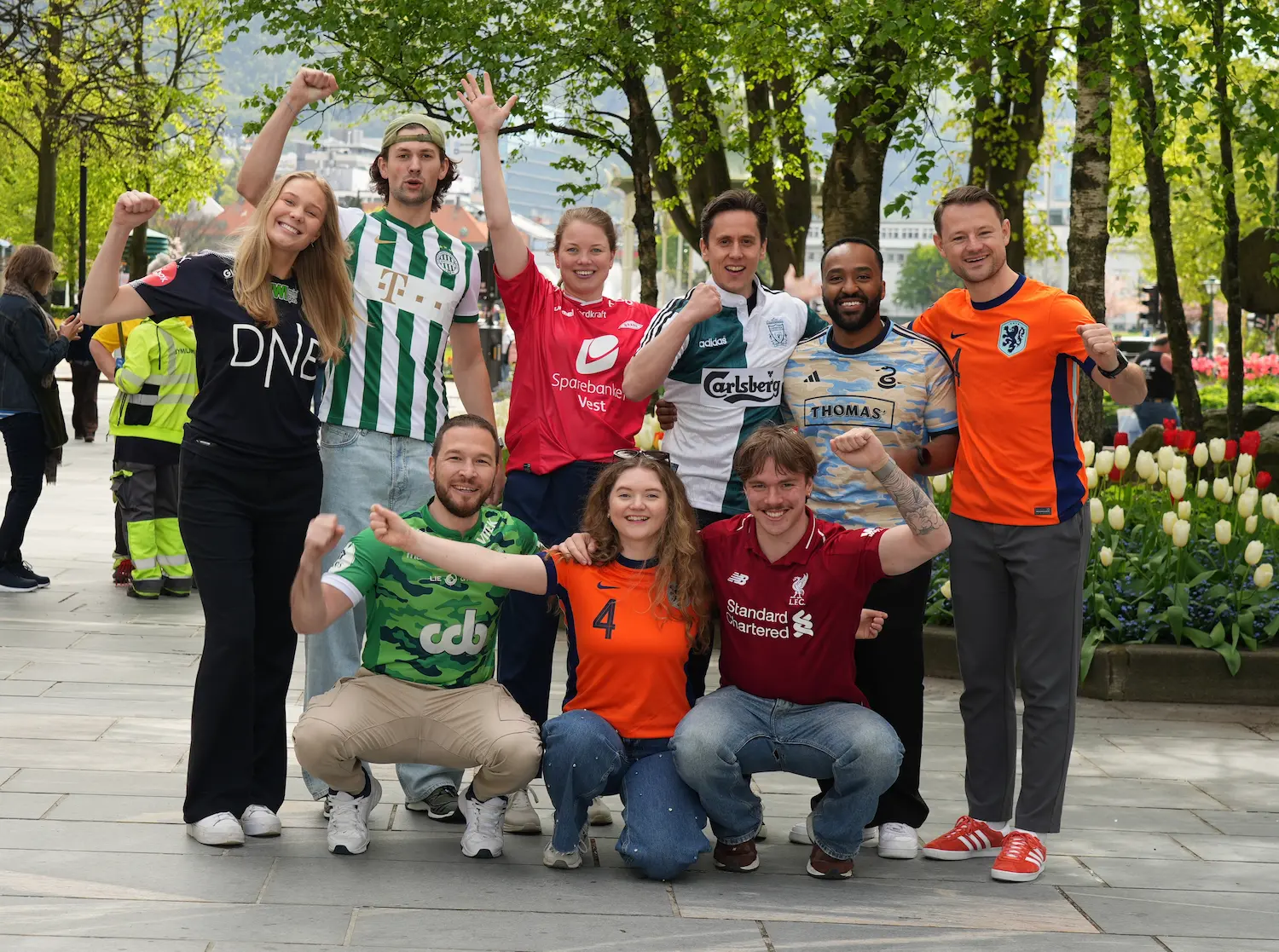 The Kravia team in football shirts, cheering in a city park